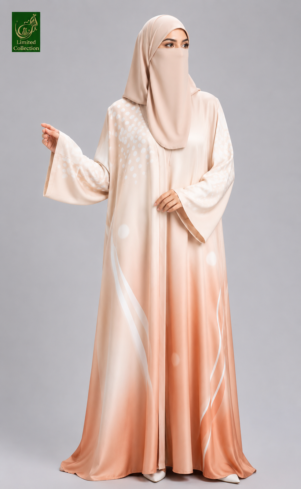 A woman wearing a flowing abaya and matching hijab in a soft peach and cream gradient, standing against a light gray studio background. A small green 'Ladies Collection' logo appears in the top-left corner.