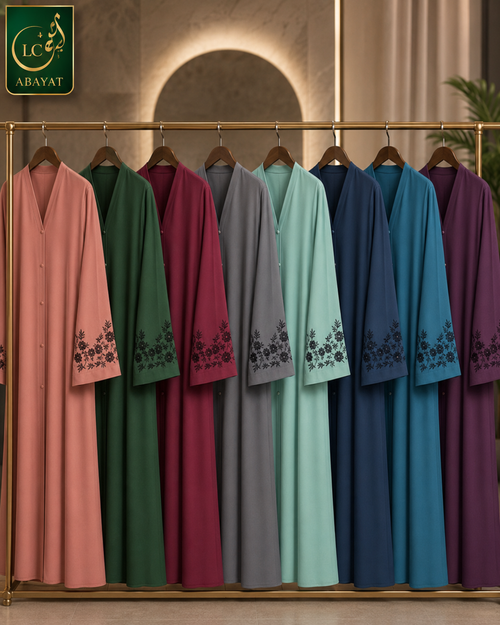 A set of women's long Abayas in multiple colors (pink, green, burgundy, gray, light blue, navy, and purple) hanging on a gold clothing rack. Each Abaya features a V-neck, buttoned front, and black floral embroidery on the cuffs.