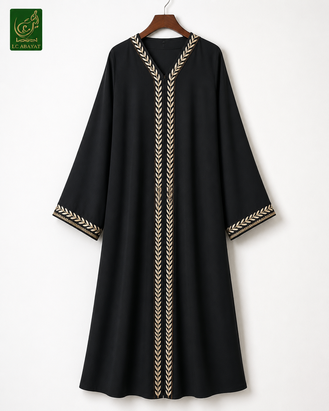 A black long-sleeve abaya dress with gold chevron leaf embroidery on the neckline, front, and cuffs, hanging on a wooden hanger against a plain white wall.