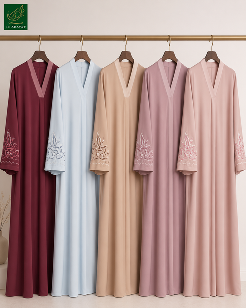 Five long V-neck Iris blossom embroidered cuff Abayas hanging on a gold clothing rack against a light beige wall. The Abayas come in five colorways: burgundy, light blue, beige, mauve, and blush pink.