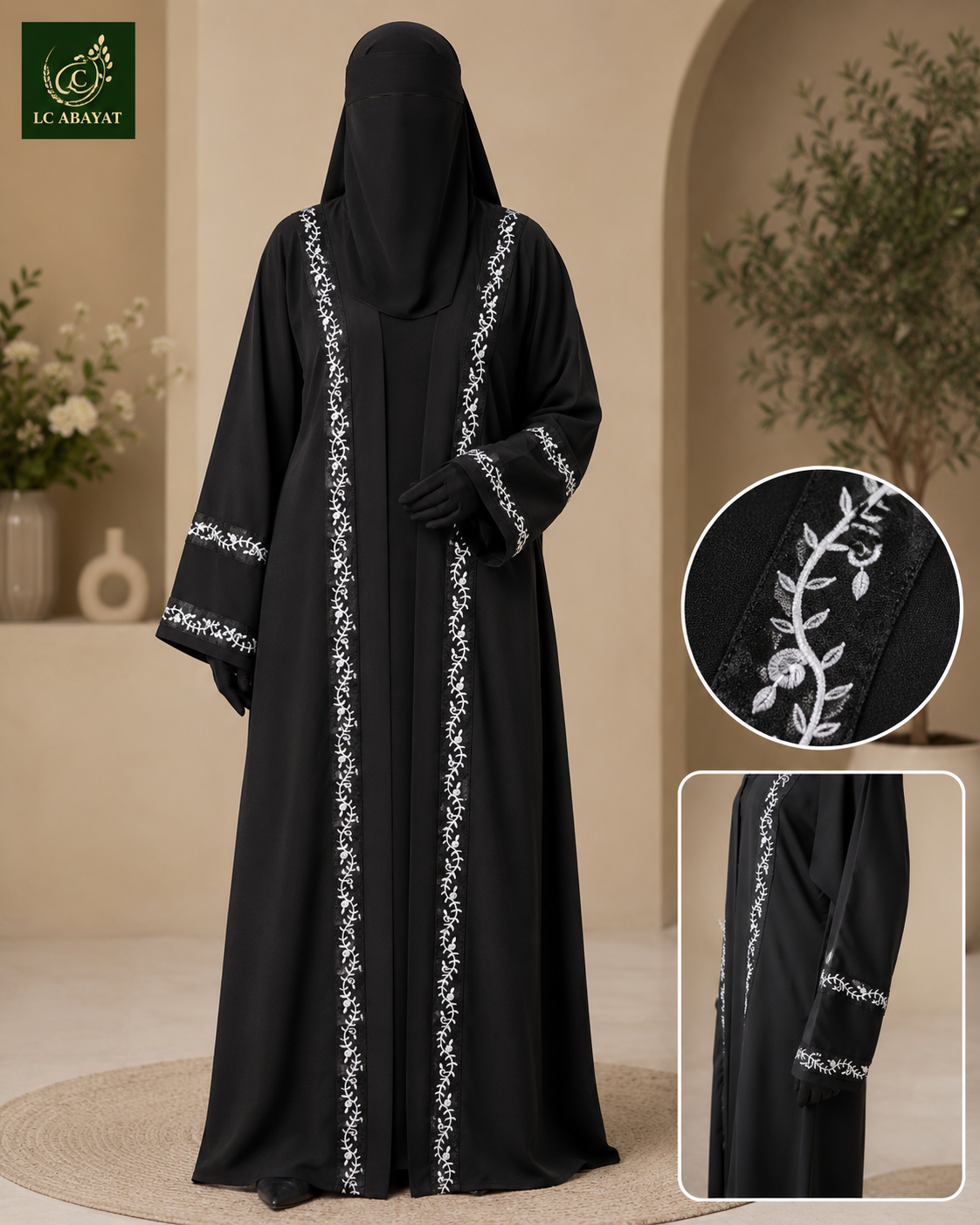 A woman modeling a black abaya with white leafy vine embroidery along the front and sleeve cuffs, shown in a warm beige indoor setting. Two inset close-ups on the right show detailed embroidery and fabric texture.