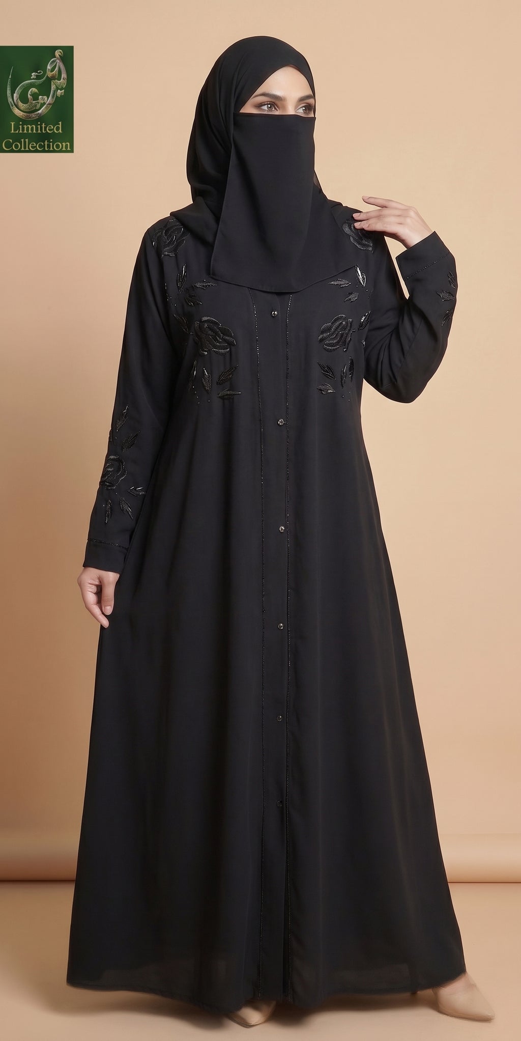 A woman wearing a long black abaya with embroidered details and a matching black face veil, standing against a solid beige background. A green 'United Collection' logo is visible in the top left corner.