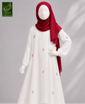 A mannequin wearing a white long-sleeve abaya dress with small pink bow embroidery and a deep red hijab, photographed against a soft gray studio background. A green 'Limited Collection' logo appears in the top-left corner.