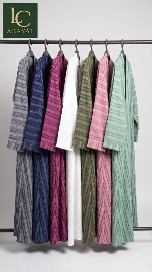 A set of women's long-sleeve front open brochia abaya in multiple colors (gray, navy, magenta, olive green, white, pink, and mint green) hanging on a metal rack against a light gray background. The 'LC ABAYAT' brand logo is visible in the top left corner.