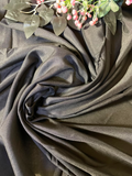 Dark charcoal gray draped fabric with a soft sheen, styled in a spiral drape with decorative artificial leaves and pink berries at the top.