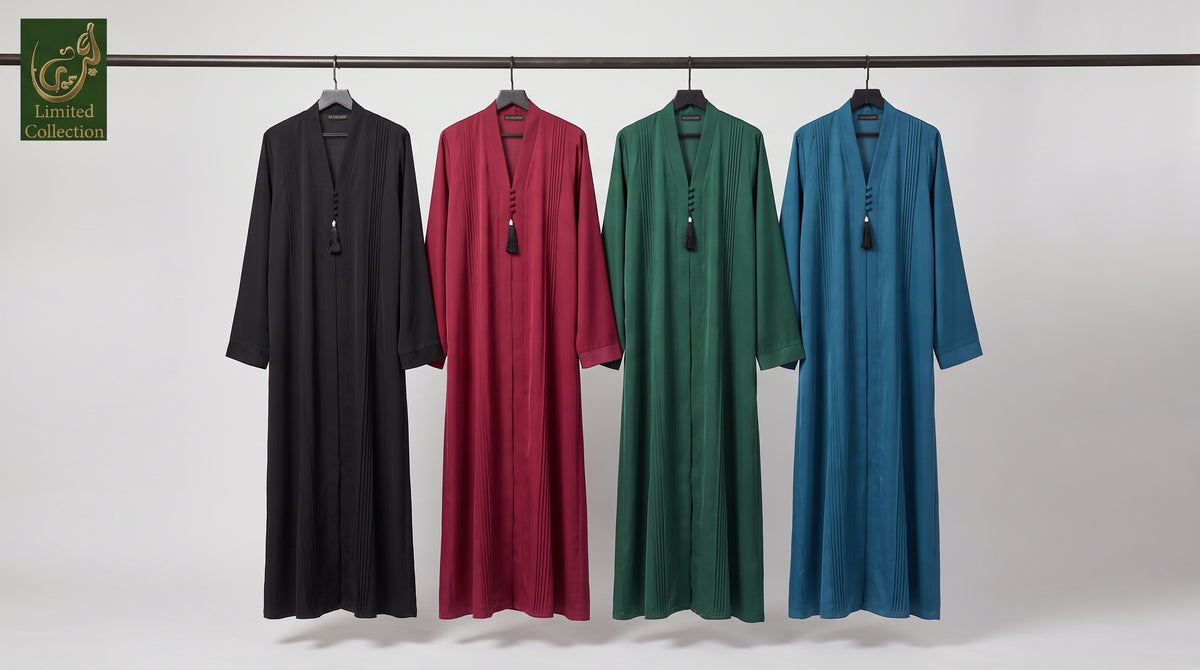 Four long flowing Dubai Style Pleated Maxi Abaya With Tassel Button in Premium Romantic Nida fabric  hanging on a black rail against a light gray studio background. From left to right, the colors are black, deep burgundy, forest green, and medium blue.