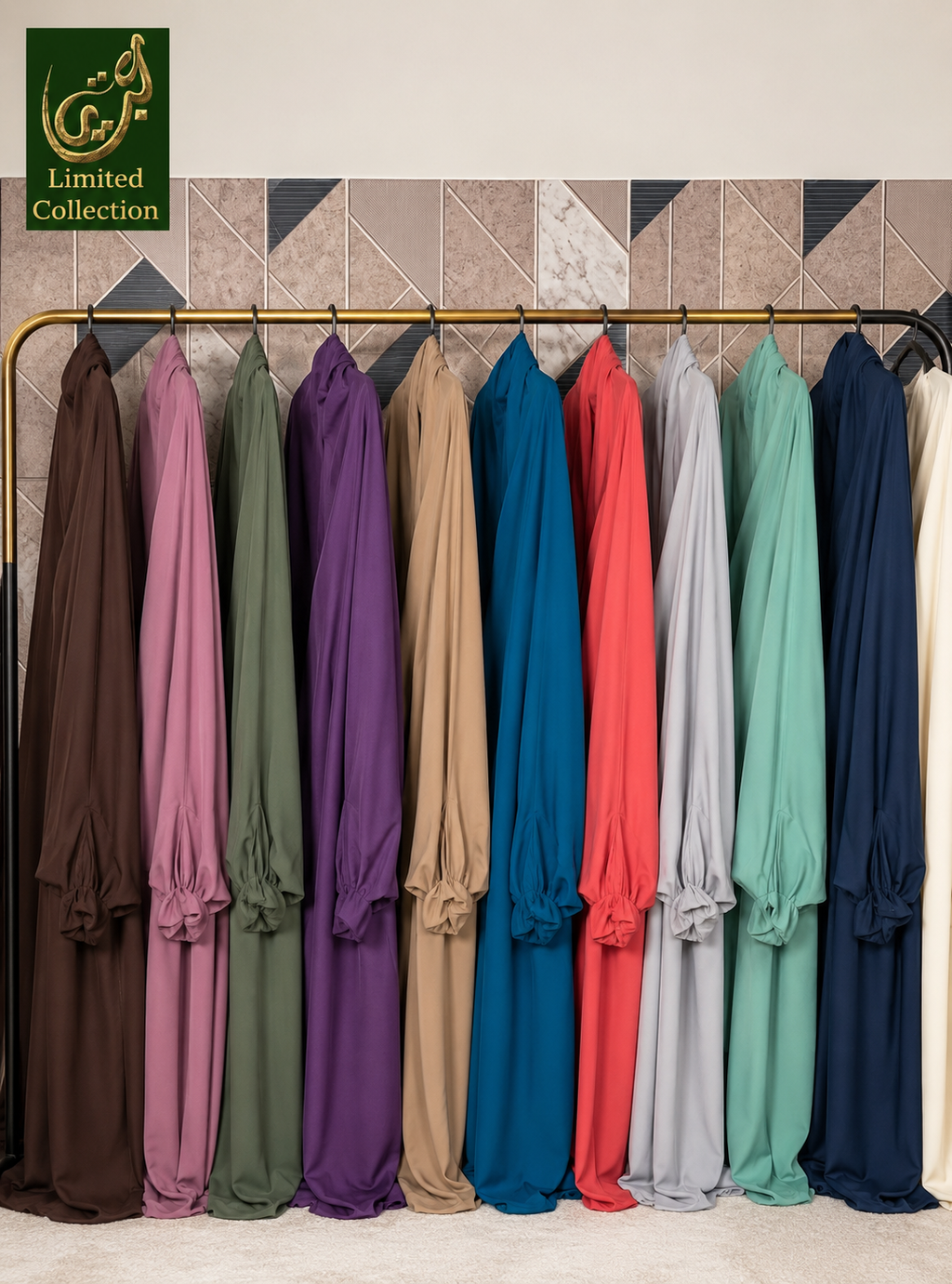 A row of long flowing jilbabs in multiple colors hanging on a rack against a patterned wall. The garments include brown, dusty pink, sage green, purple, tan, teal blue, coral red, light gray, mint green, dark navy, and cream.
