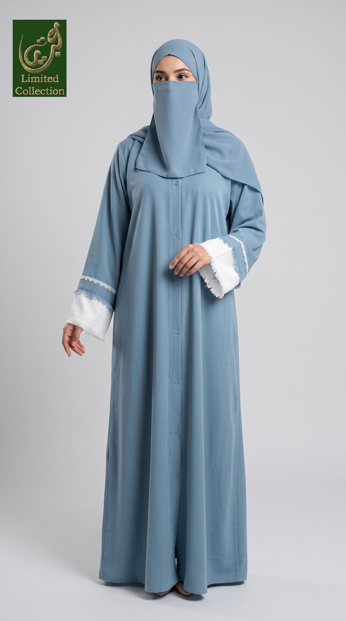 A woman modeling a light blue abaya and matching hijab set with white lace trim on the sleeves, photographed against a plain light gray studio background. A green 'Limited Collection' logo appears in the top-left corner.