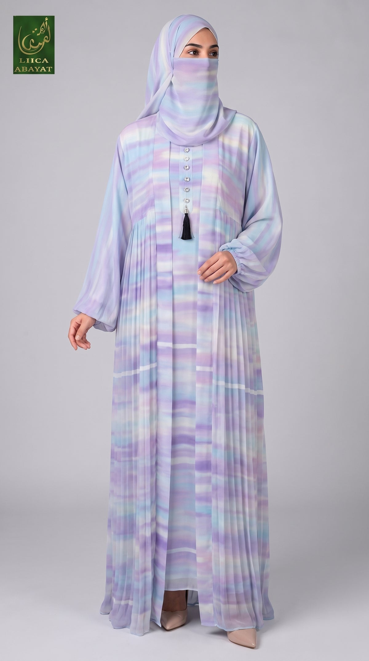 A woman modeling a long, flowing Cotton Candy Tie-Dye Front-open Kimono Abaya 2pcs set with a matching hijab and face covering. The garment has a pastel tie-dye pattern in lavender, purple, blue, and white.