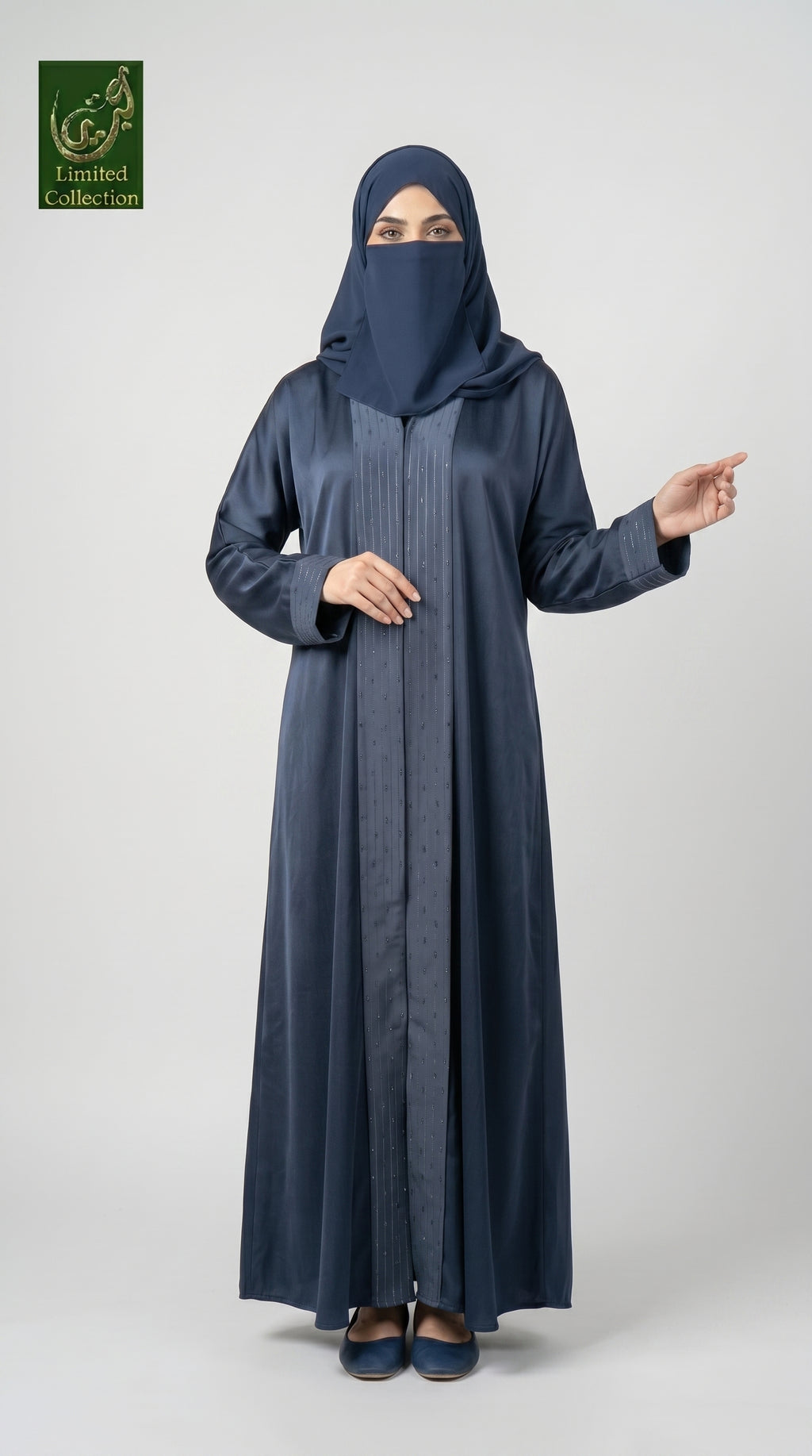 A woman wearing a long navy blue abaya with a matching hijab and dark flat shoes, standing against a light gray studio background. She is gesturing with her right hand, and a green 'Limited Collection' logo is visible in the top-left corner.