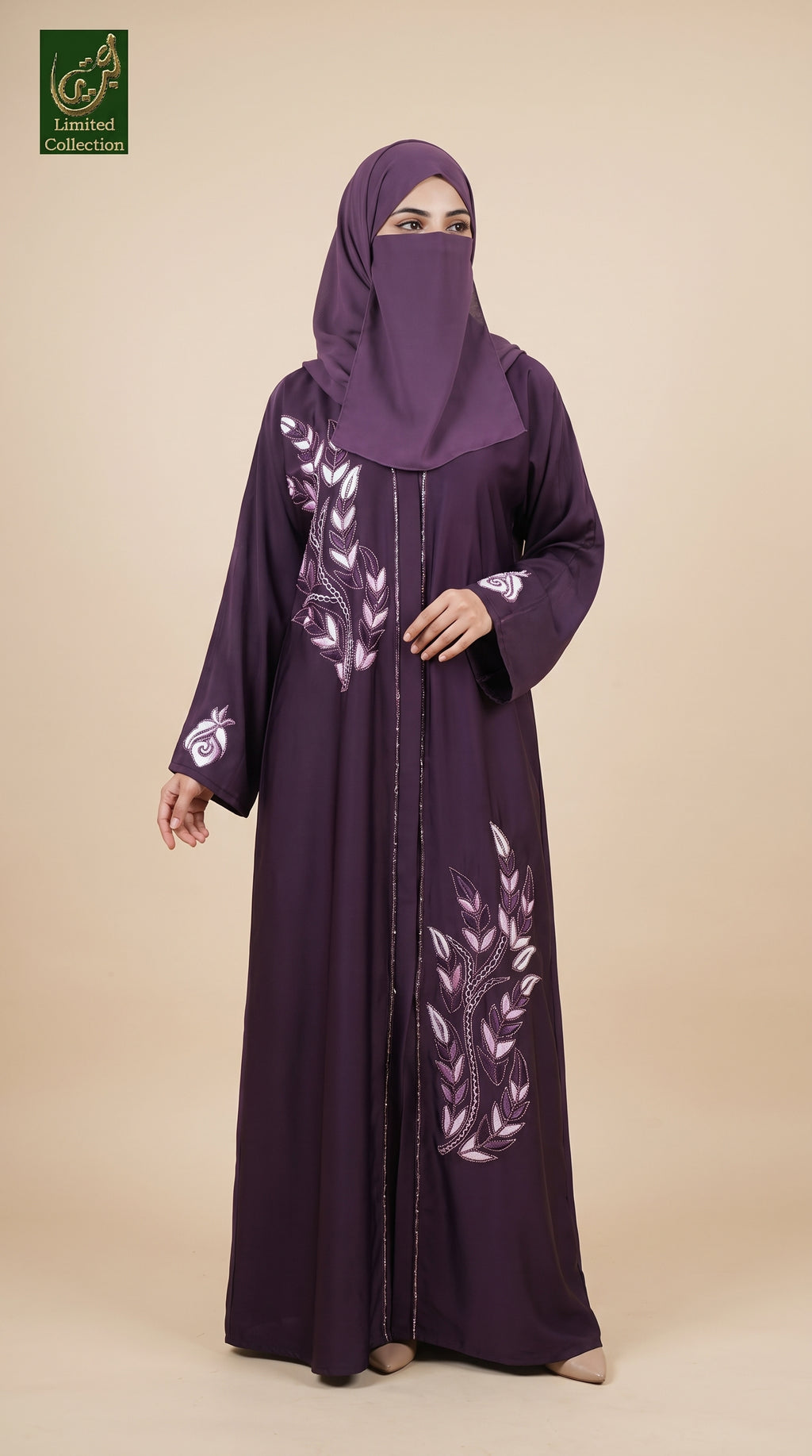 A woman wearing a long purple abaya with white floral embroidery and a matching purple hijab, standing against a solid beige background. A green 'Limited Collection' logo is visible in the top-left corner.