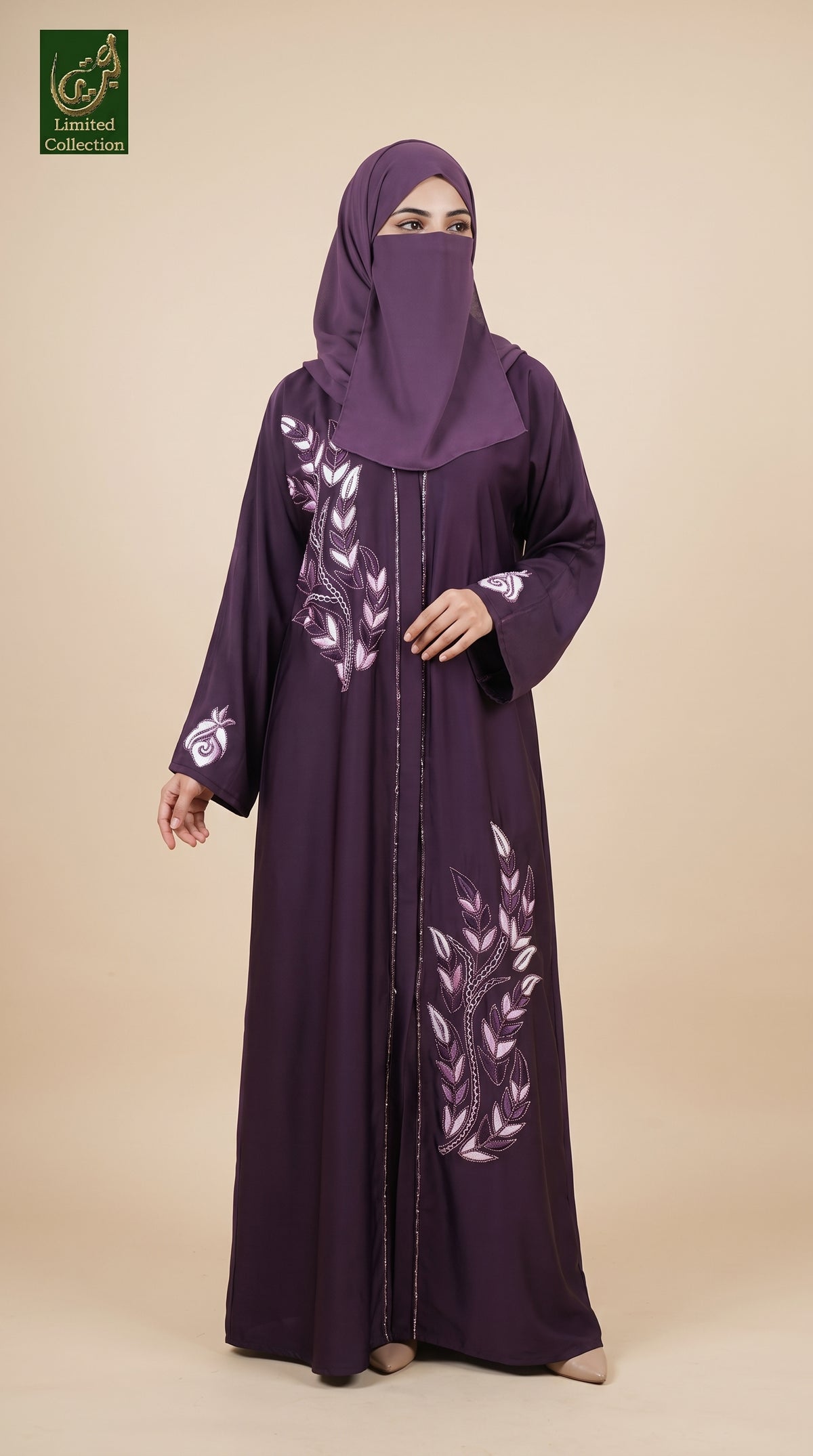 A woman wearing a long purple abaya with white floral embroidery and a matching purple hijab, standing against a solid beige background. A green 'Limited Collection' logo is visible in the top-left corner.