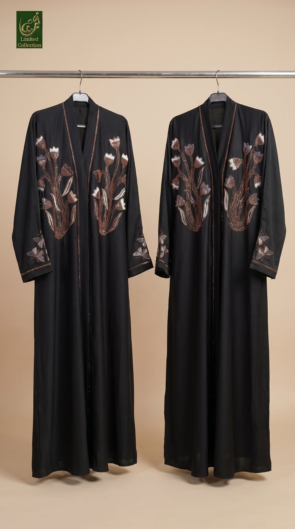 Two black long open-front robes with brown and beige floral embroidery, hanging on a metal rack against a beige studio background.