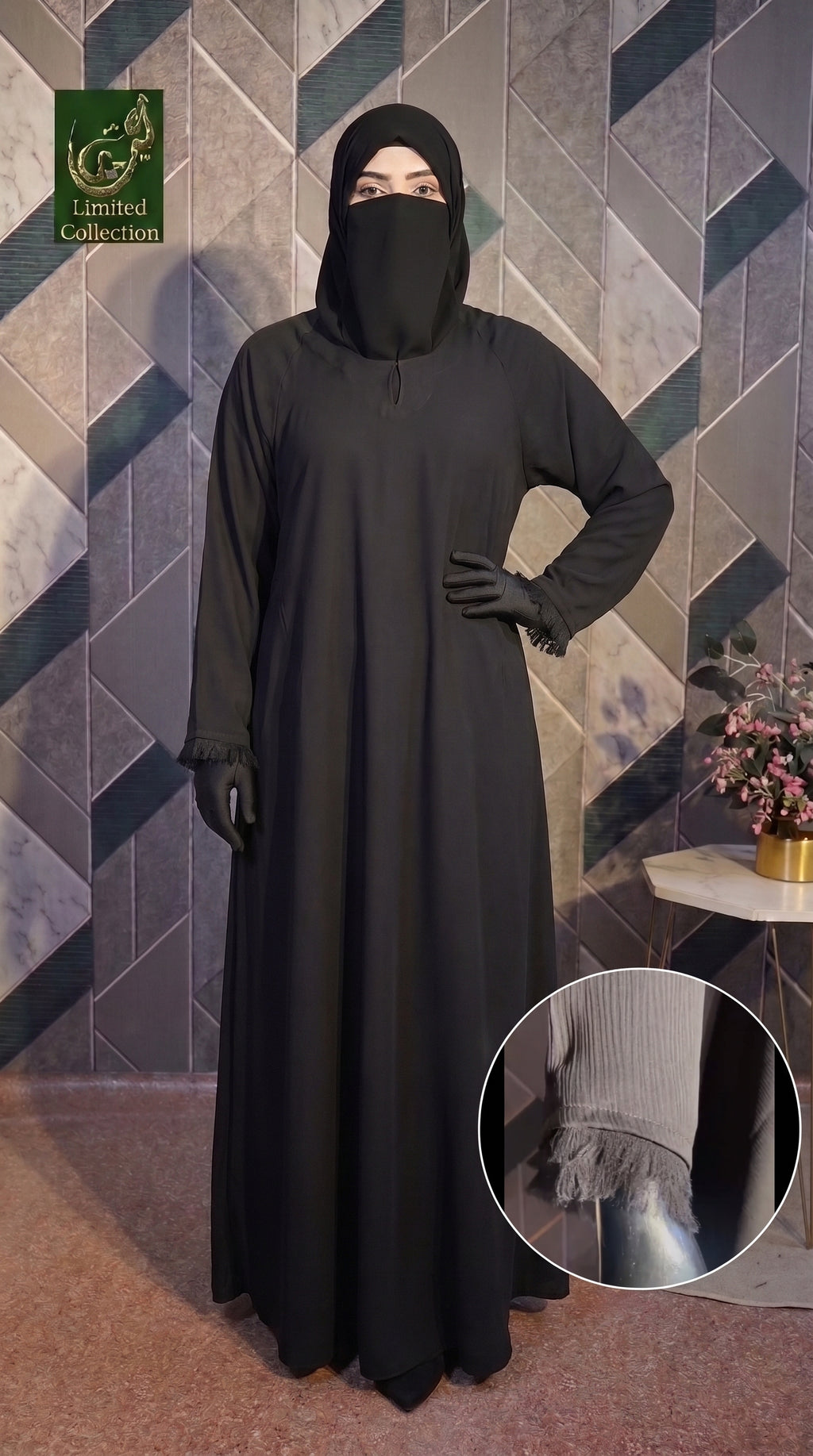 A woman modeling a long black Front-Closed Feather Cuff Maxi abaya with a matching black face covering and gloves, standing against a geometric patterned wall. A circular inset at the bottom right shows a close-up of the sleeve cuff detail.