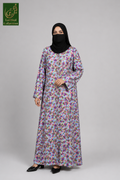 A woman modeling a long-sleeved floral front-open abaya with a black hijab and black shoes, standing against a solid gray studio background. The abaya features a dense multicolor floral print on a light lavender-purple base.