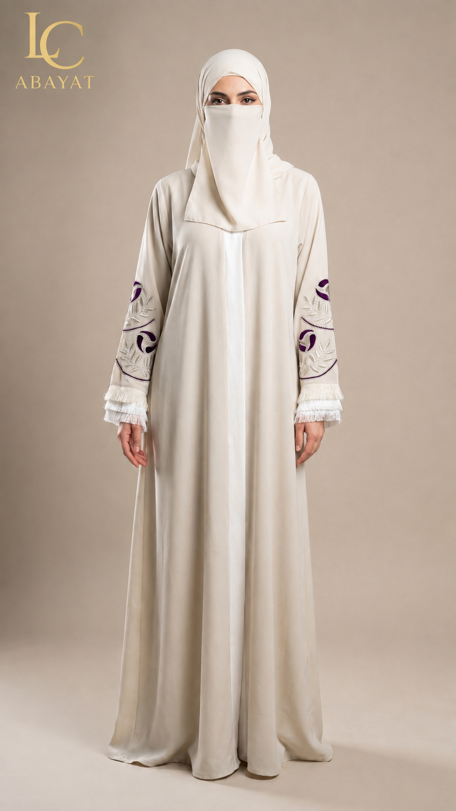A woman wearing a long cream abaya with purple embroidered details on the sleeves and a matching cream hijab, standing against a solid beige studio background. The LC Abayat brand logo is visible in the top left corner.