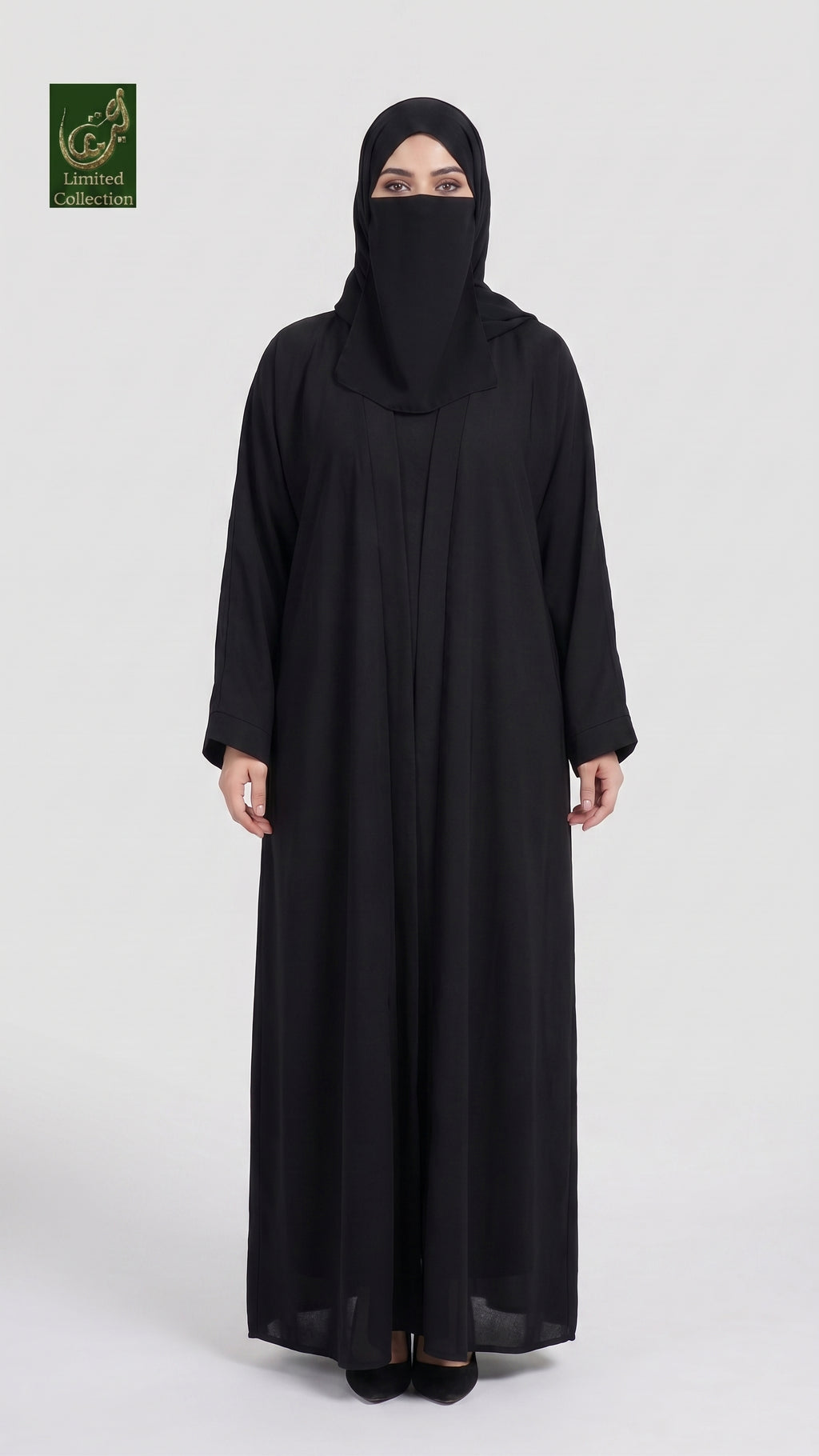 A woman wearing a long black abaya and matching black hijab stands against a light gray studio background. A small green logo appears in the top-left corner.