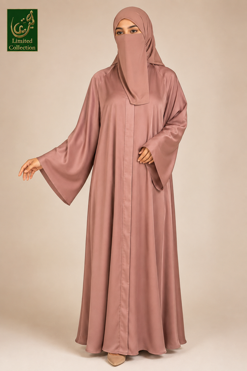 A woman wearing a dusty rose abaya and matching hijab, standing against a solid beige studio background. A green 'Limited Collection' logo is visible in the top-left corner.