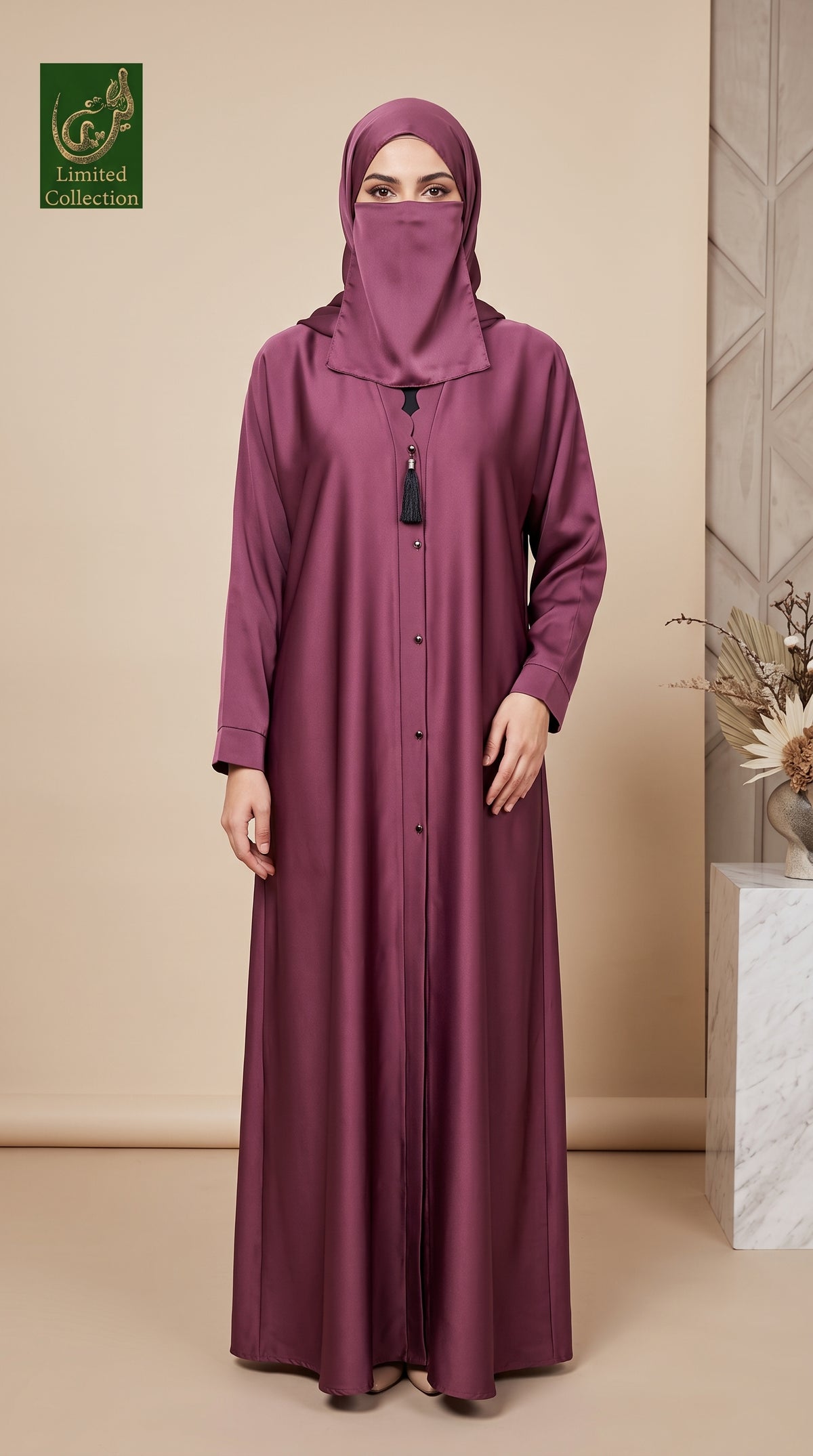 A woman wearing a long, floor-length mauve-purple abaya with a matching hijab and face veil, standing in a studio with a beige background and a decorative plant on the right.
