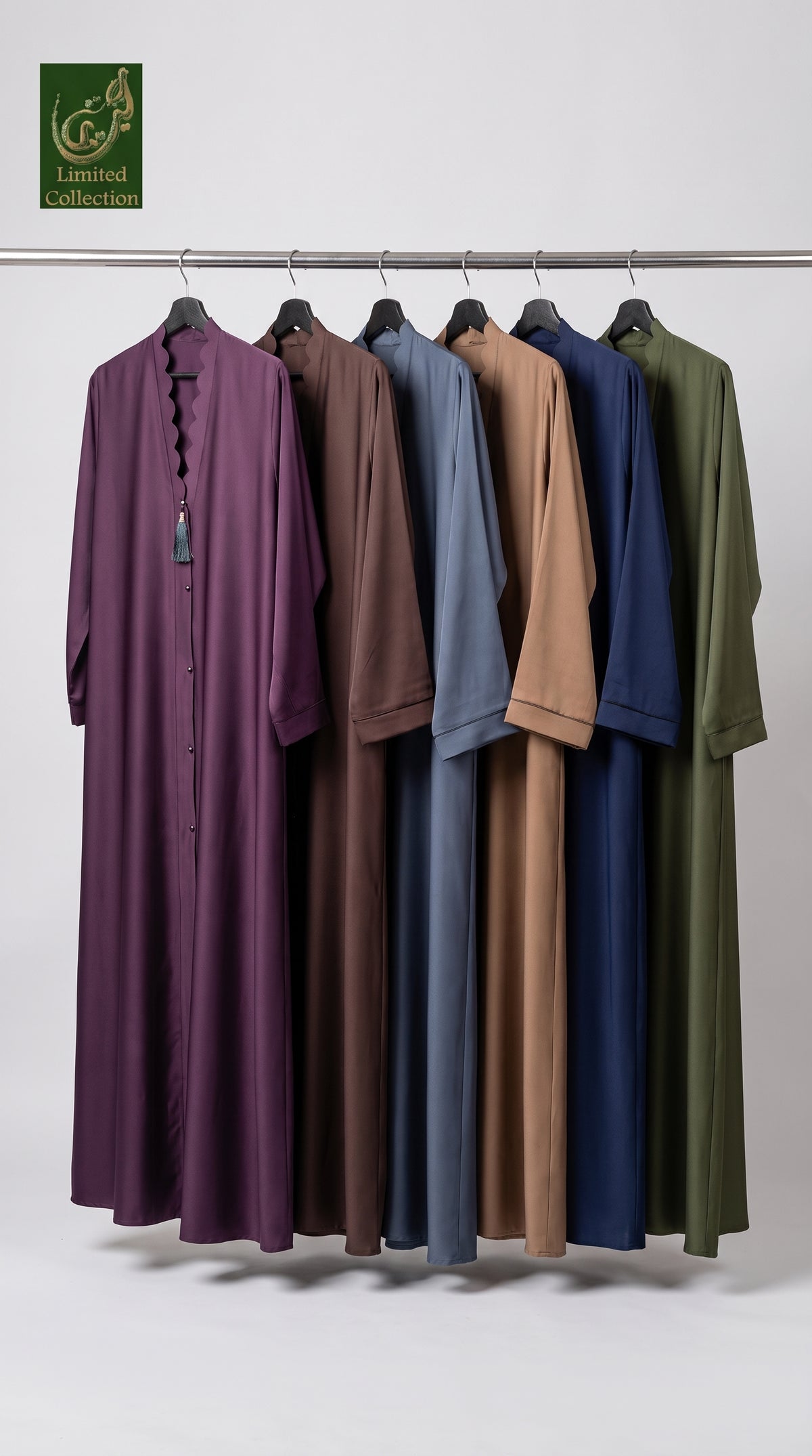 Six long loose-fitting abaya hanging on a metal rack against a light gray studio background. The garments are shown in multiple colors: purple, brown, dusty blue, tan, navy, and olive green.