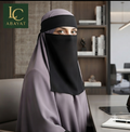 A woman wearing a modest head covering in a muted dusty lavender and black, seated at a desk in an office environment. The brand logo 'LC ABAYAT' is visible in the top-left corner.