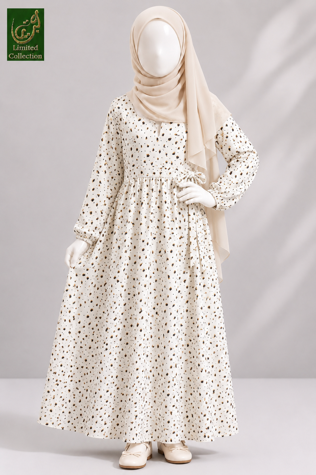 A long-sleeved cream-colored modest Maxi Abaya with a small brown floral print, styled on a mannequin with a beige hijab and cream shoes. The image has a green 'Limited Collection' logo in the top-left corner.