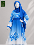 A blue and white printed hijab Abaya displayed on a mannequin, featuring a blue hijab, long-sleeved dress with blue floral prints fading to white, and white shoes, set against a neutral gray background.