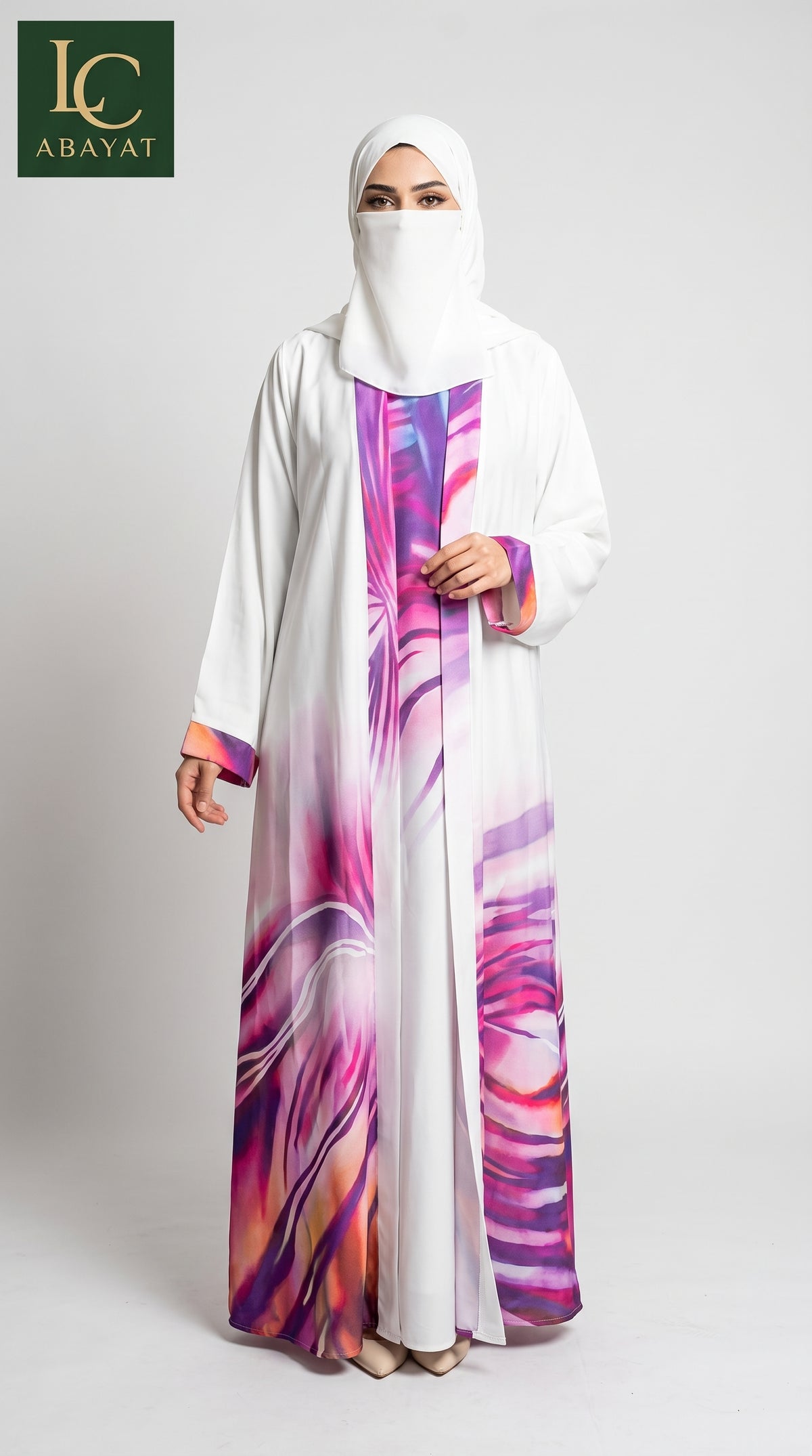 A woman modeling a white abaya with a vibrant purple, pink, and orange abstract floral print along the front panel and hem, paired with a matching white hijab. The brand logo 'LC ABAYAT' is visible in the top left corner.