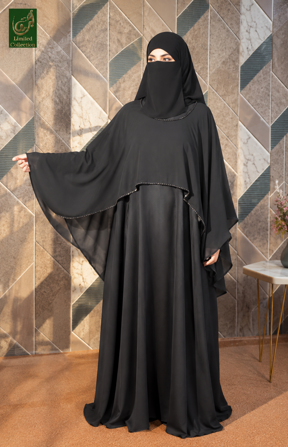 A woman wearing a full black modest Maxi Abaya with a face veil and long flowing shrug, standing indoors against a geometric tiled wall. A small 'Limited Collection' logo appears in the top-left corner.