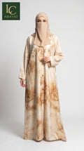 A beautiful model wearing a marble print front open abaya with button plackets. Standing against a studio backdrop. The brand is LC Abayas.