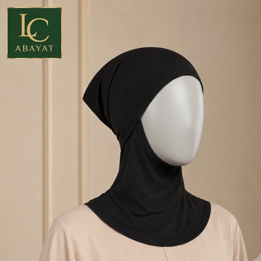 A black ninja-style hijab cap displayed on a white mannequin head and upper torso, against a warm beige background. A green square logo in the top left reads LC ABAYAT.