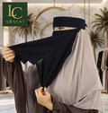 A woman wearing a beige and brown modest outfit with a black face veil, holding it open in a boutique setting. The logo 'LC ABAYAT' is visible in the top left corner.