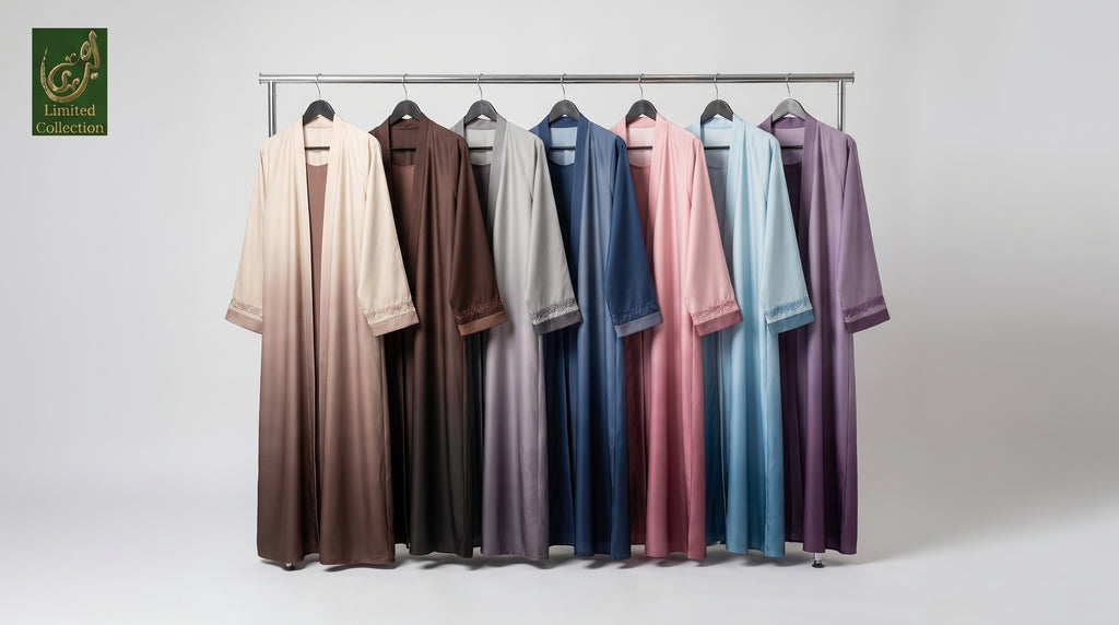Six long open-front robes or kaftan-style garments in different colors hang on a metal rack against a light gray studio background. The colors shown are cream, brown, taupe, blue, pink, light blue, and purple.