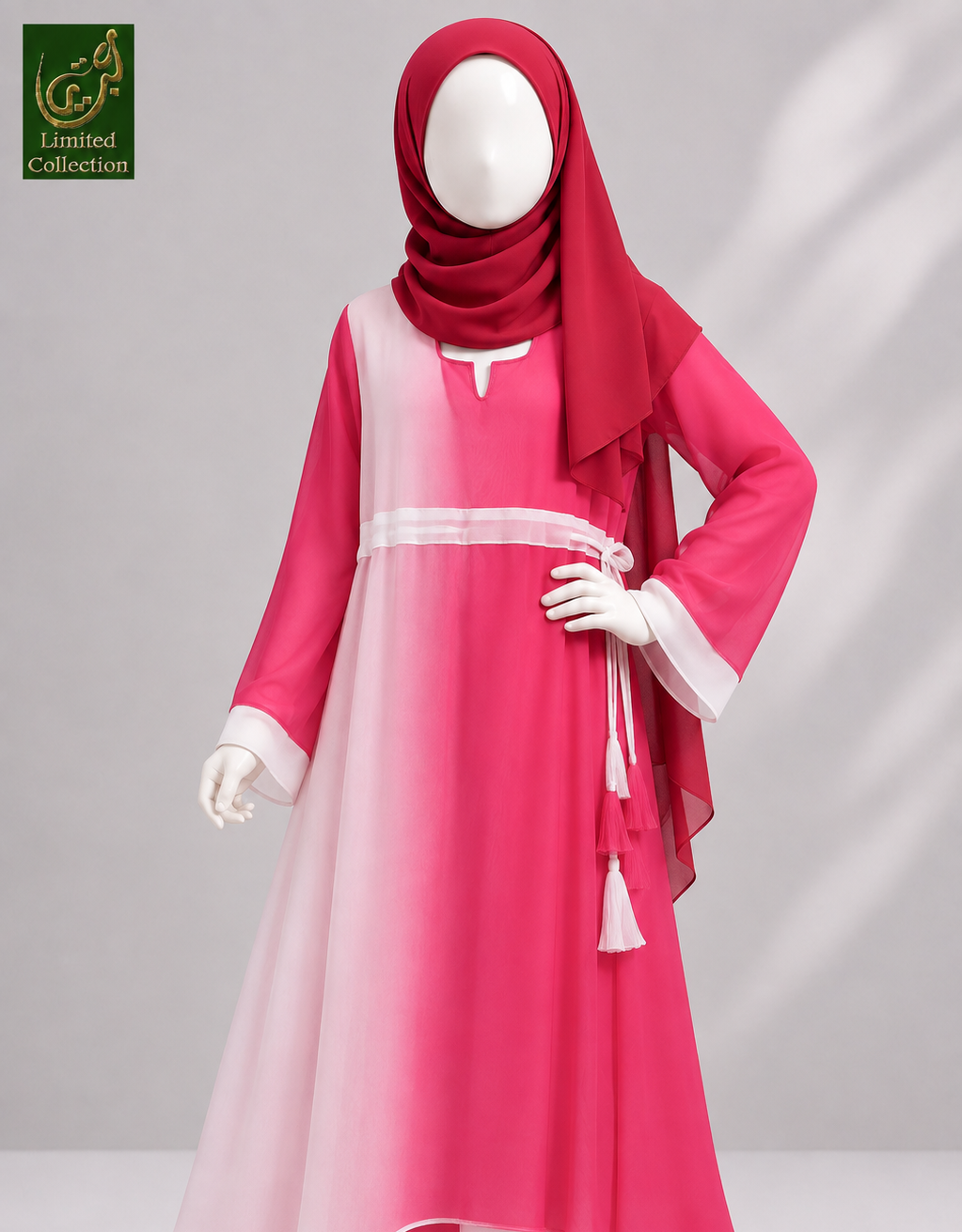 A young girl's modest ombre abaya featuring a long-sleeved pink and white gradient abaya dress with a matching red hijab, displayed on a mannequin against a gray studio background.