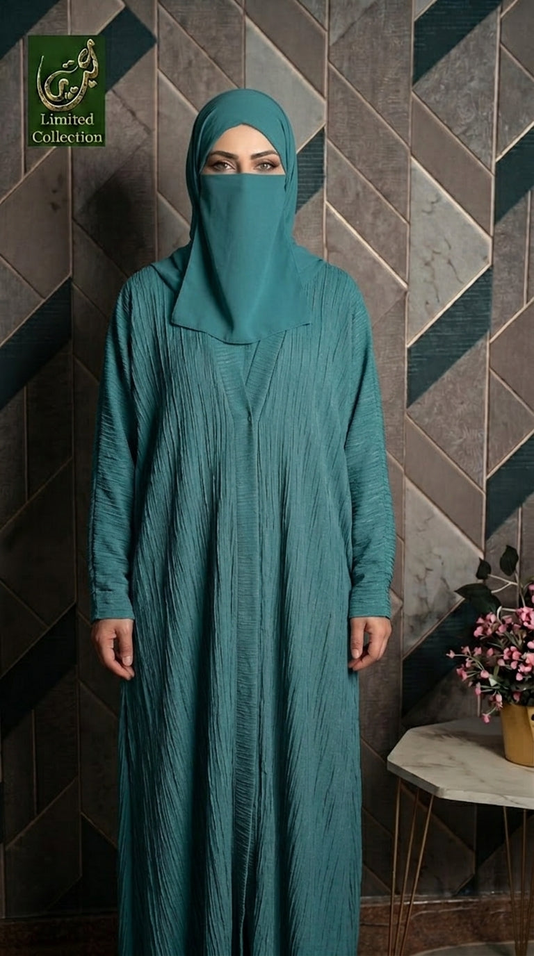 A woman wearing a teal-green crinkled abaya and matching hijab stands in front of a geometric patterned wall. A logo in the top-left corner reads 'Limited Collection'.