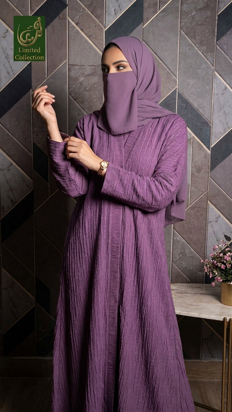 A woman wearing a long-sleeved, floor-length mauve-purple abaya with a matching hijab, standing in front of a geometric tiled wall. A green 'CJCL Limited Collection' logo is visible in the top-left corner.