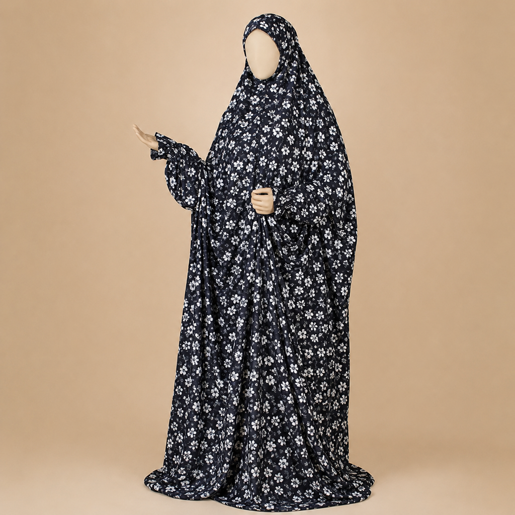 A full-body black modest garment with a white floral print, displayed on a mannequin against a solid beige background.
