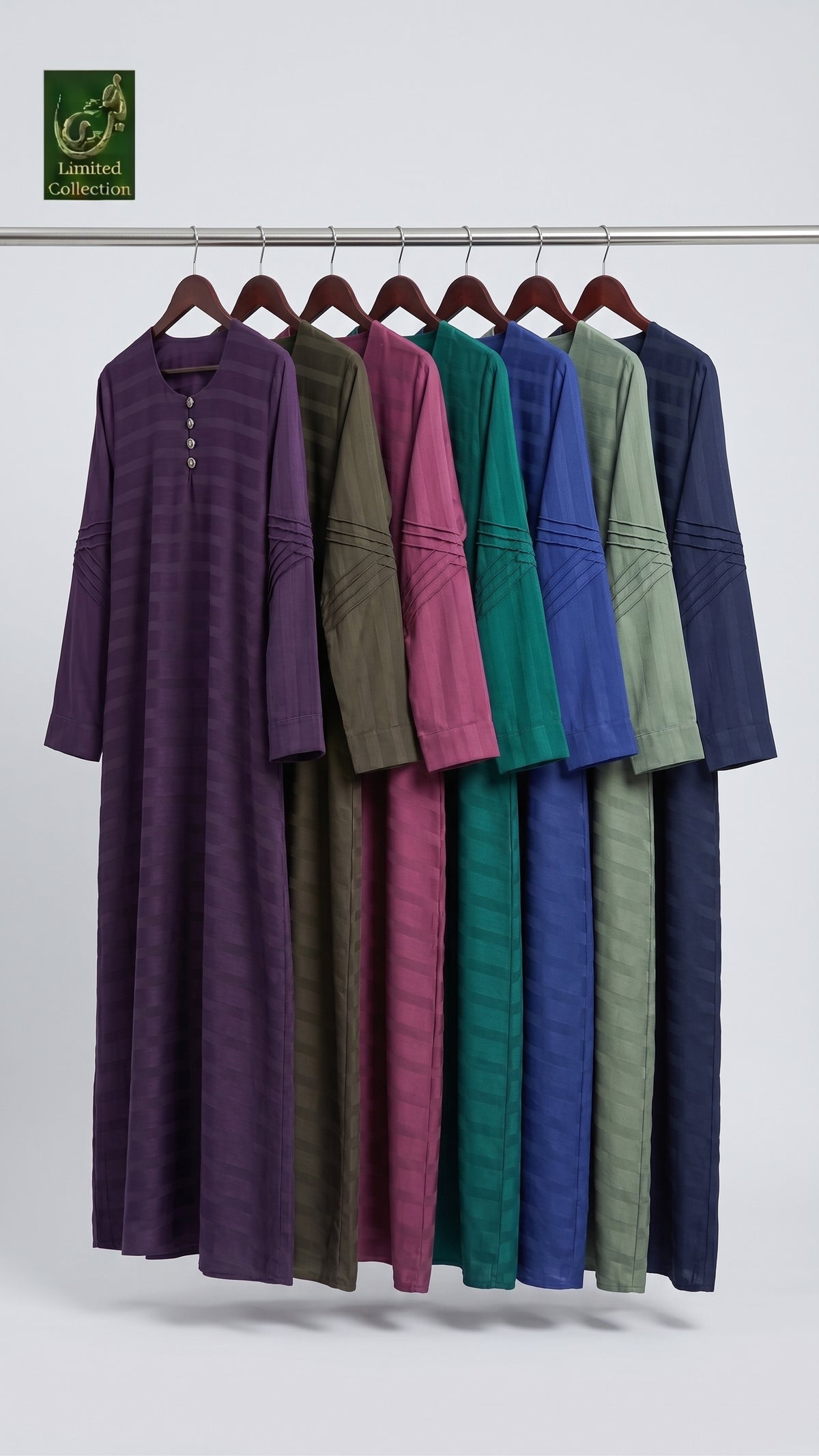 Seven long-sleeve Front Closed Maxi Abayas in different colors hang on a metal rack against a light gray studio background. The dresses include purple, olive green, magenta, teal, blue, and sage green, each with a subtle horizontal stripe pattern and decorative sleeve embroidery.