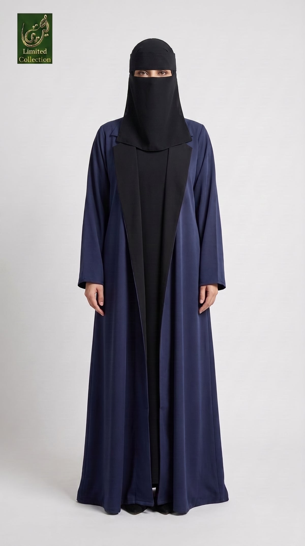 A woman modeling a long navy blue abaya with a black inner layer and a black face covering, standing against a light gray studio background. A green 'Khumail Collection' logo is visible in the top-left corner.