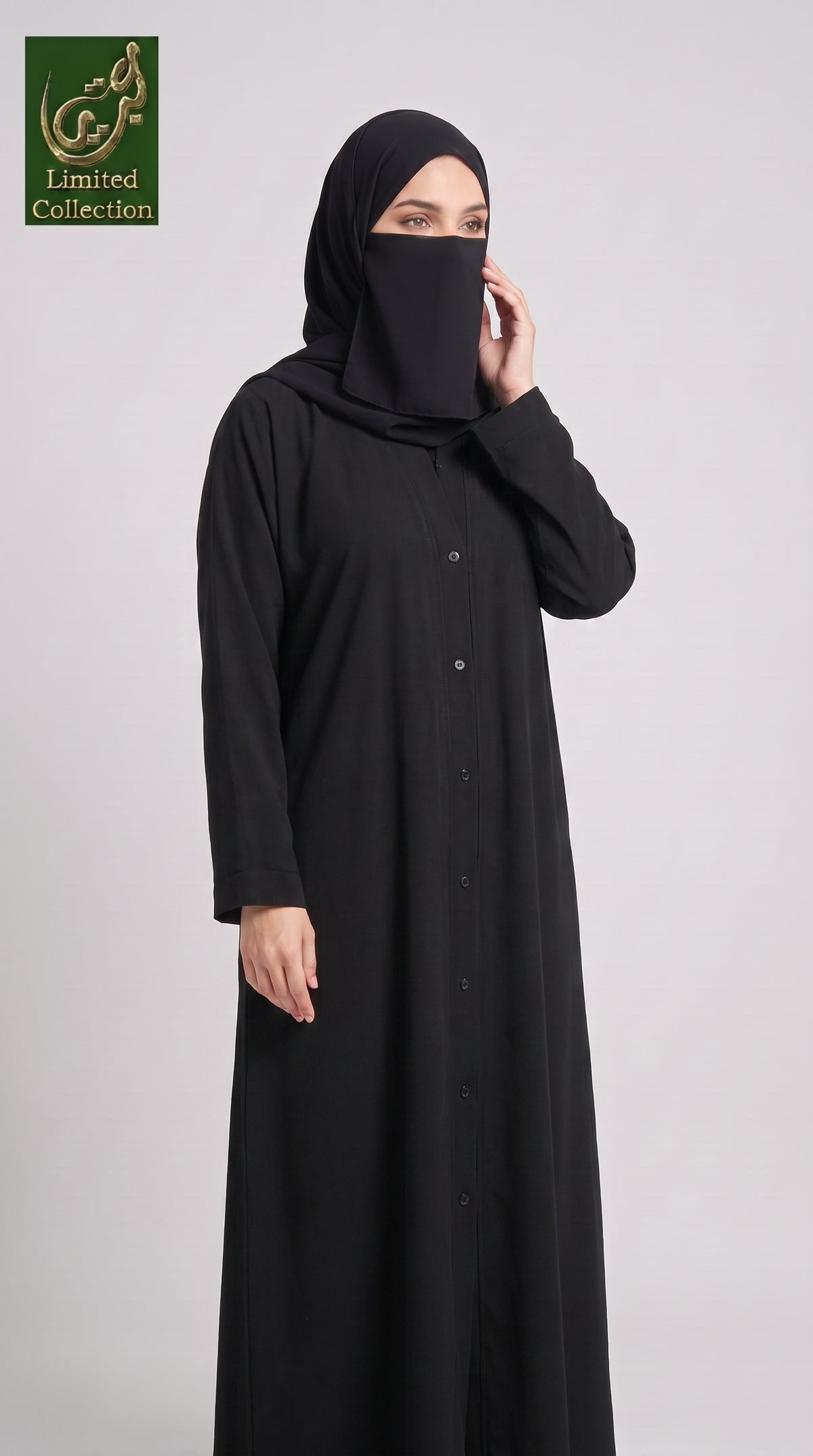 Woman wearing a sleek black abaya with button front opening. 
