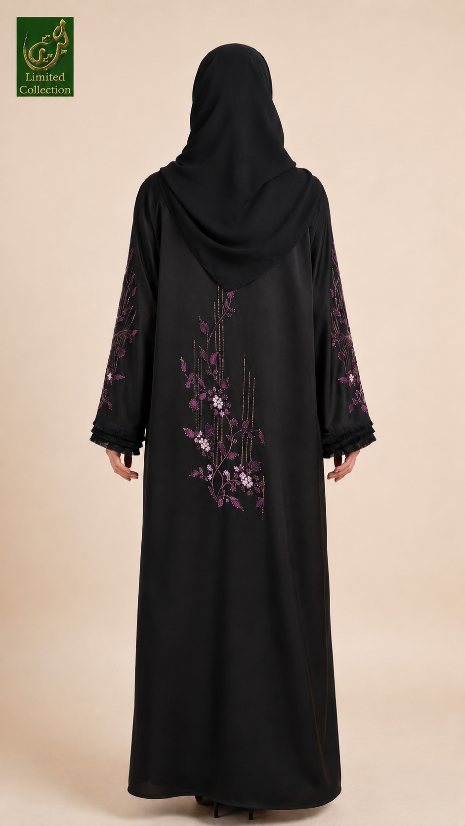 A woman wearing a black abaya with purple floral embroidery on the sleeves and back, paired with a matching black hijab, shown from the back against a solid beige background.