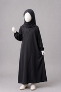 A child's full-body black abaya dress with a matching black hijab, displayed on a white mannequin against a plain gray studio background.