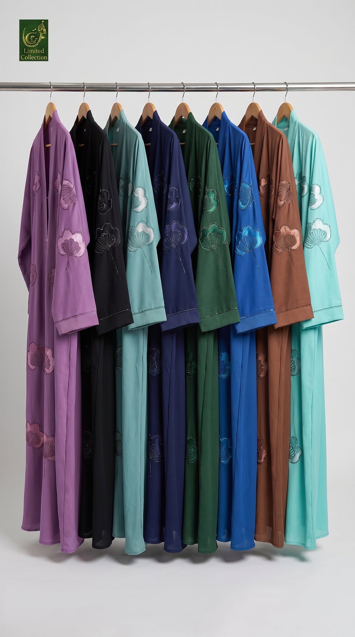 A set of front-open stone embroidery abaya in multiple colors (purple, black, mint green, navy, forest green, royal blue, terracotta brown, and light teal) hanging on a metal rack against a plain light gray background. Each robe features embroidered cloud motifs on the sleeves and skirt.