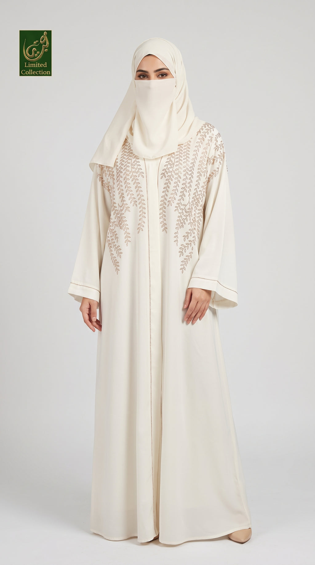 A woman wearing a long cream abaya with intricate lace embroidery on the chest, paired with a matching hijab, standing against a light gray studio background. A green 'Limited Collection Abayat' logo is visible in the top-left corner.