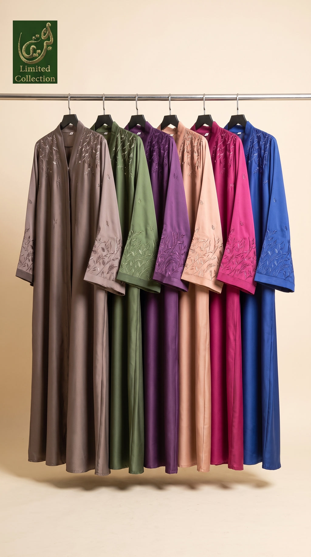 A set of long, loose-fitting abaya dresses hanging on a metal rack against a warm beige background. The collection includes multiple colors: taupe, sage green, plum purple, dusty pink, magenta, and royal blue.