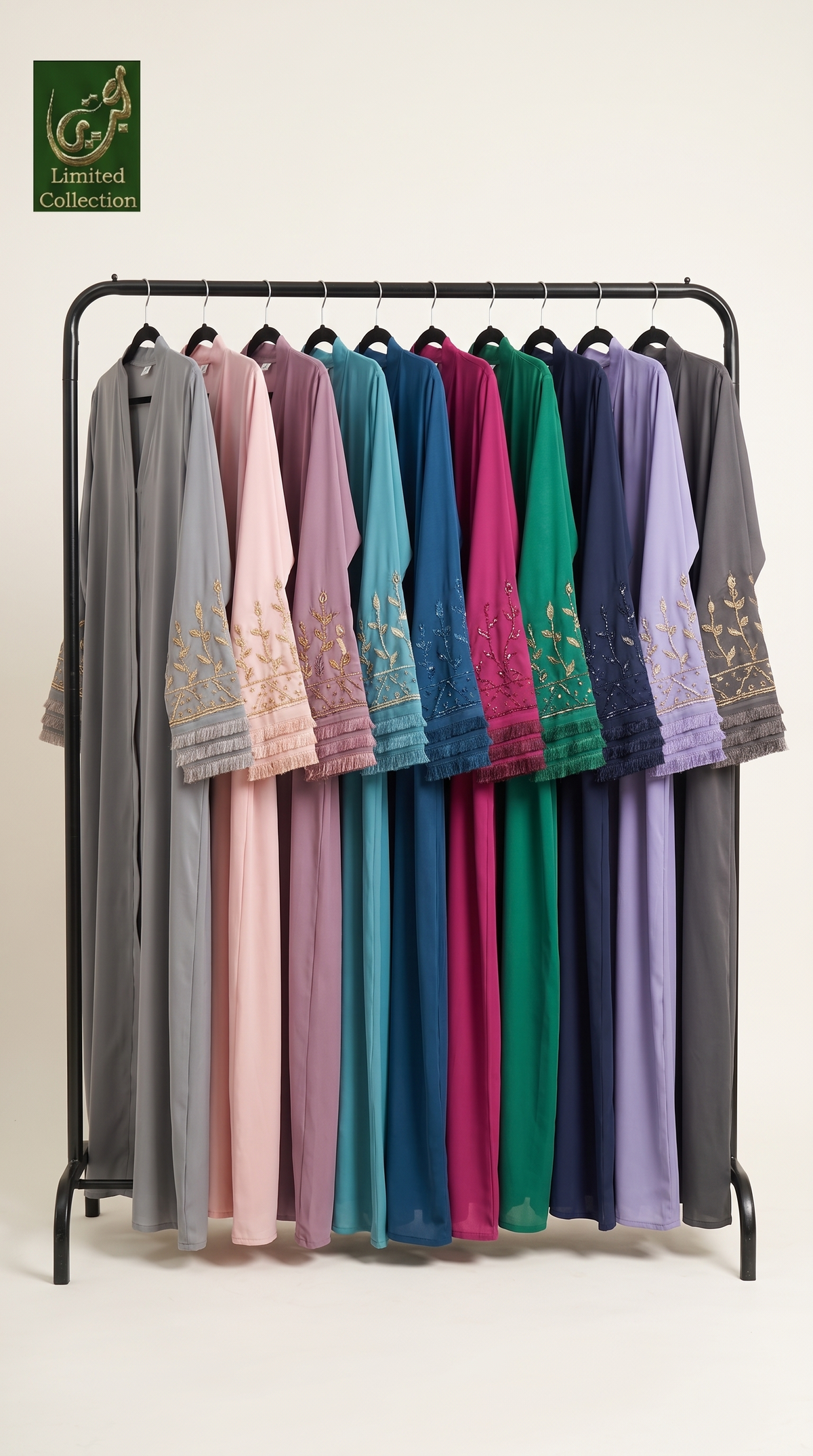 A black clothing rack displaying a collection of long, loose-fitting abaya in multiple colors, including gray, pink, purple, teal, blue, green, magenta, and lavender. Each dress features gold embroidery on the sleeves.