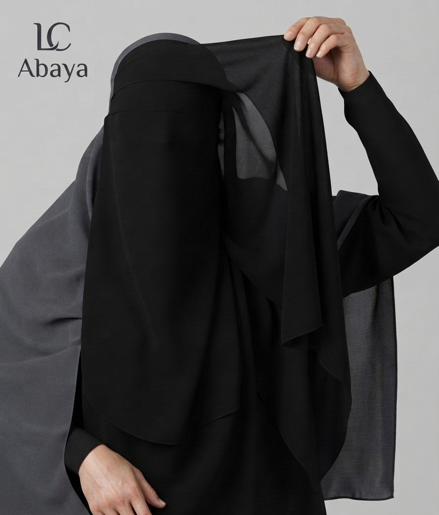 A model wearing a black abaya and a sheer black niqab, holding the nijab up with one hand. The brand logo 'LC Abaya' is visible in the top left corner against a solid gray background.