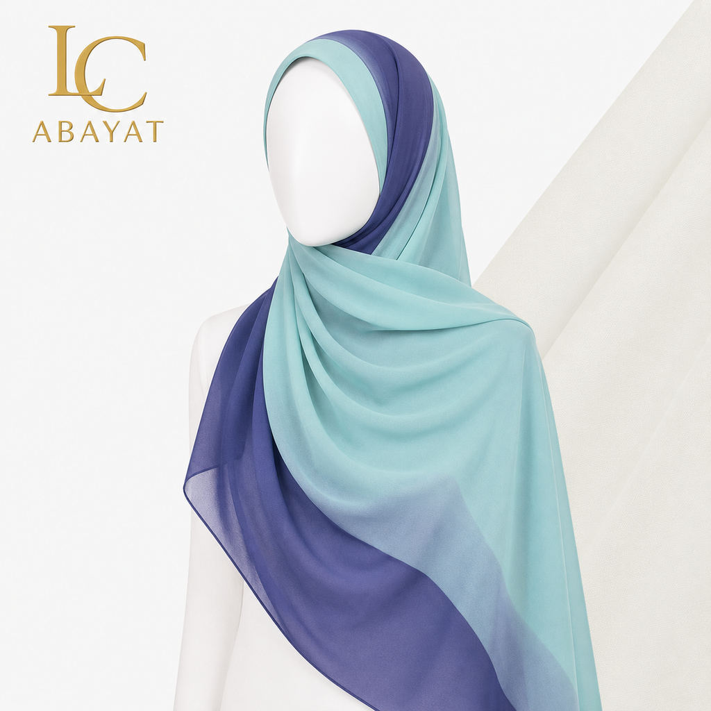 A lightweight hijab scarf draped on a white mannequin, featuring a smooth ombré transition from mint green to periwinkle blue and deep navy. The 'IC ABAYAT' brand logo is visible in the top-left corner against a clean, off-white background.