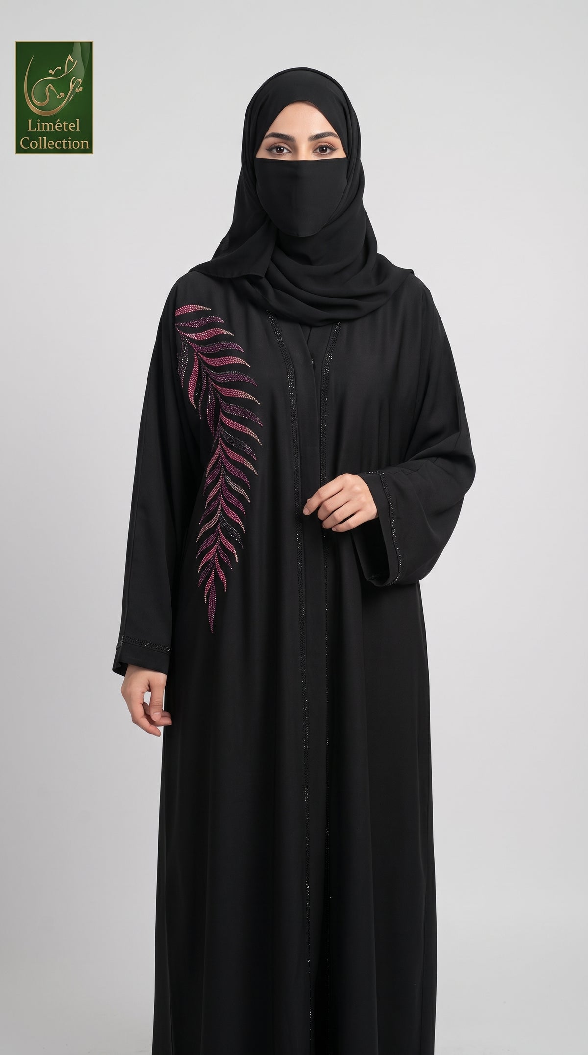 A woman wearing a black abaya with a pink embroidered leaf design on the sleeve, paired with a black hijab, standing against a light gray background. A 'Limfeet Collection' logo is visible in the top left corner.