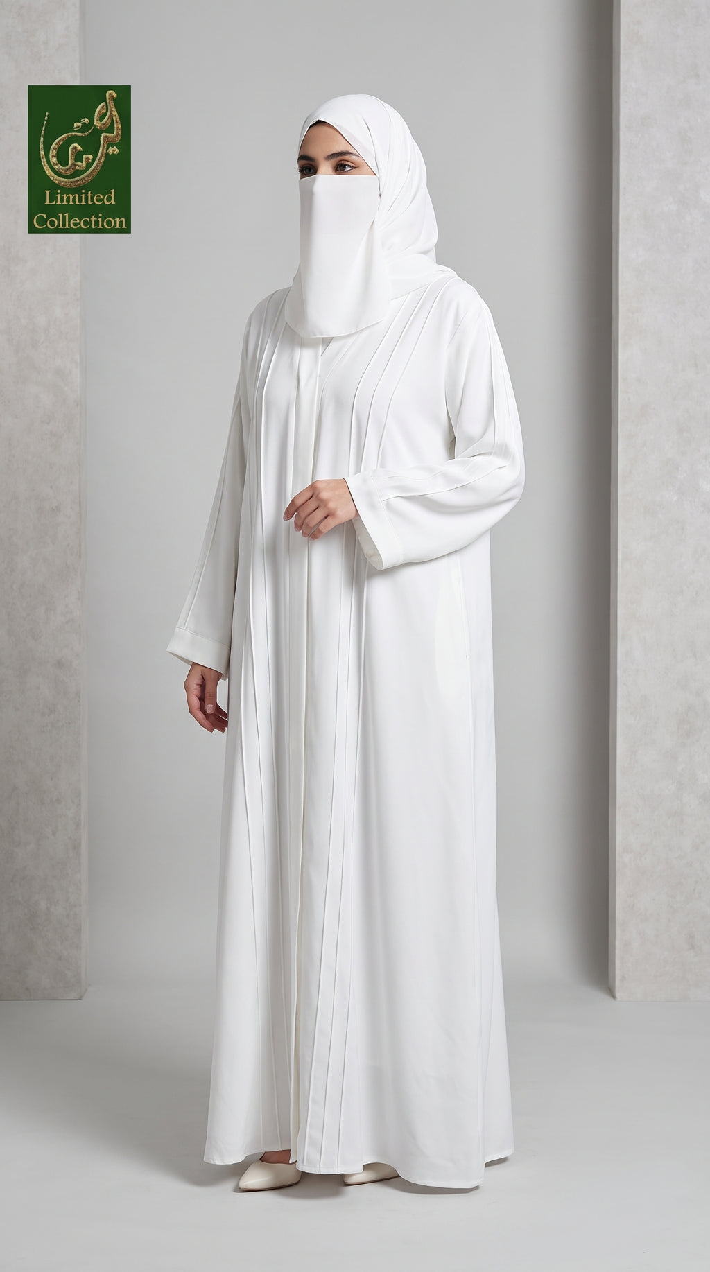 A woman wearing a white abaya and matching hijab stands in a studio setting with a light gray background. A green 'Limited Collection' logo is visible in the top-left corner.
